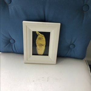Framed photo of white ballet shoe.